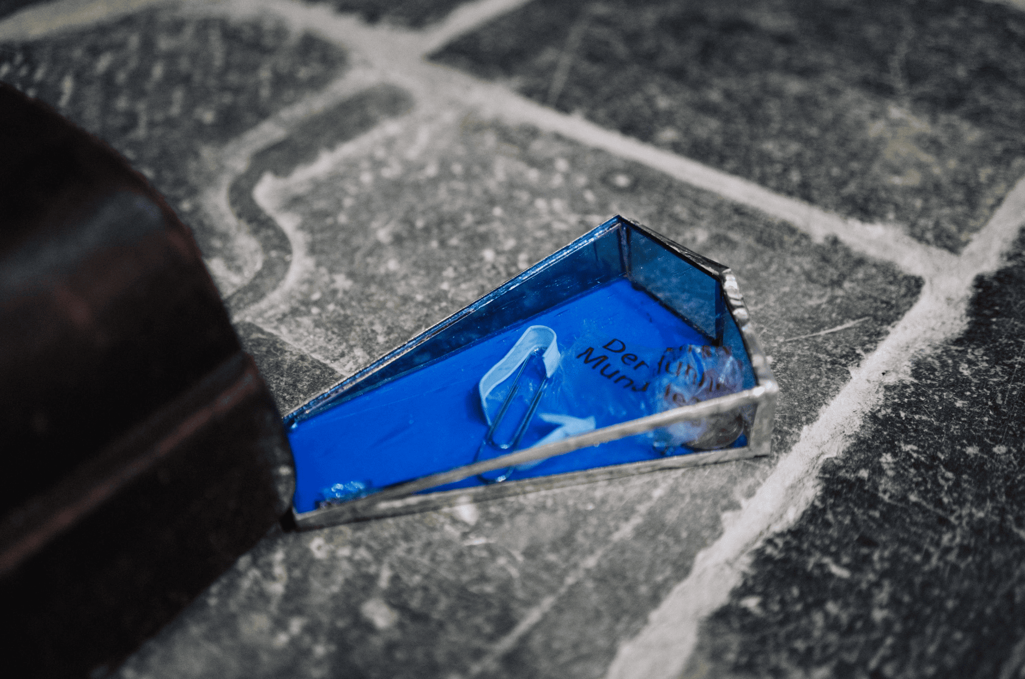 Glass doorstopper holding thrust in pinched feet